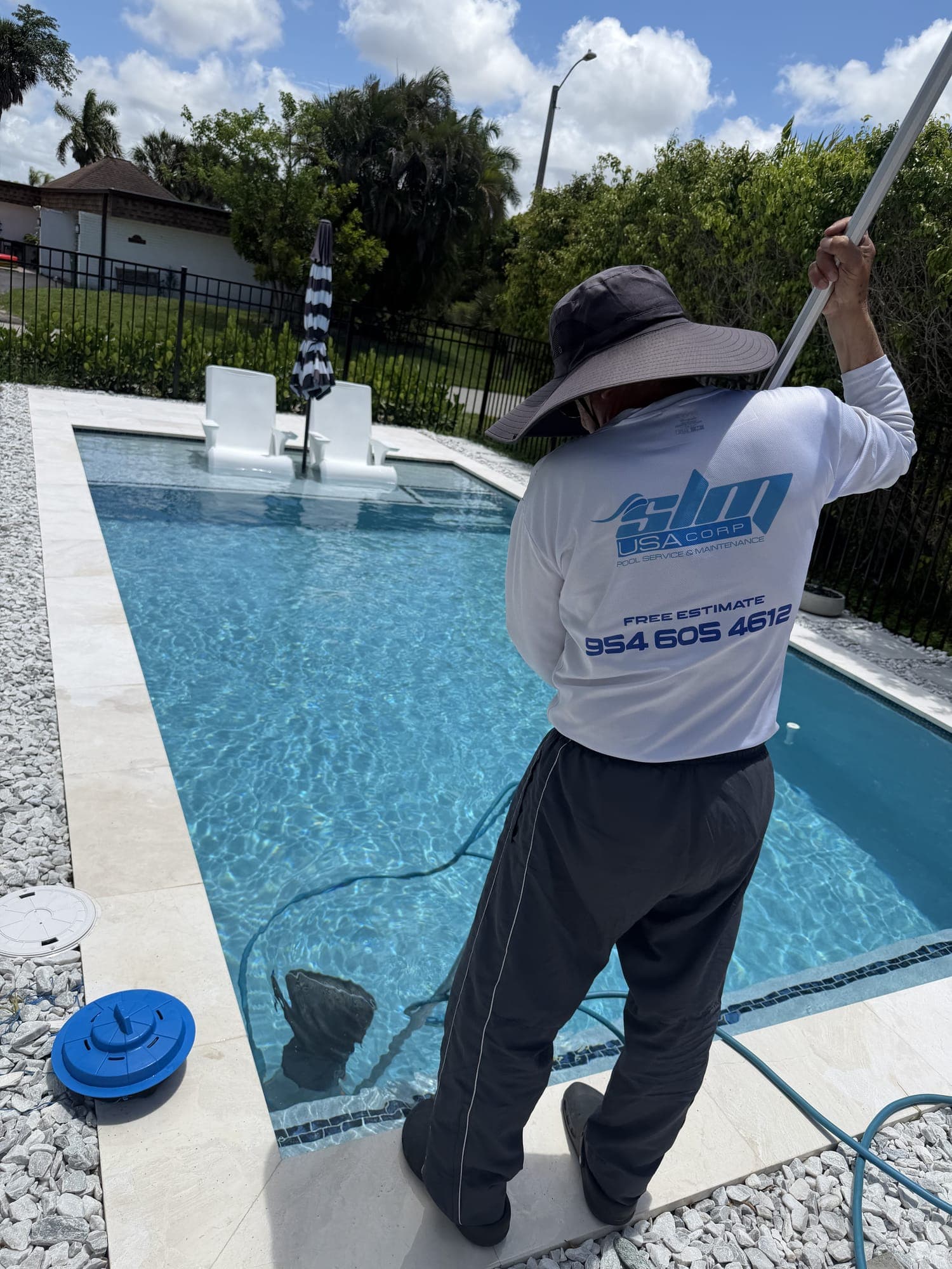 SLM technician vacuuming a backyard pool