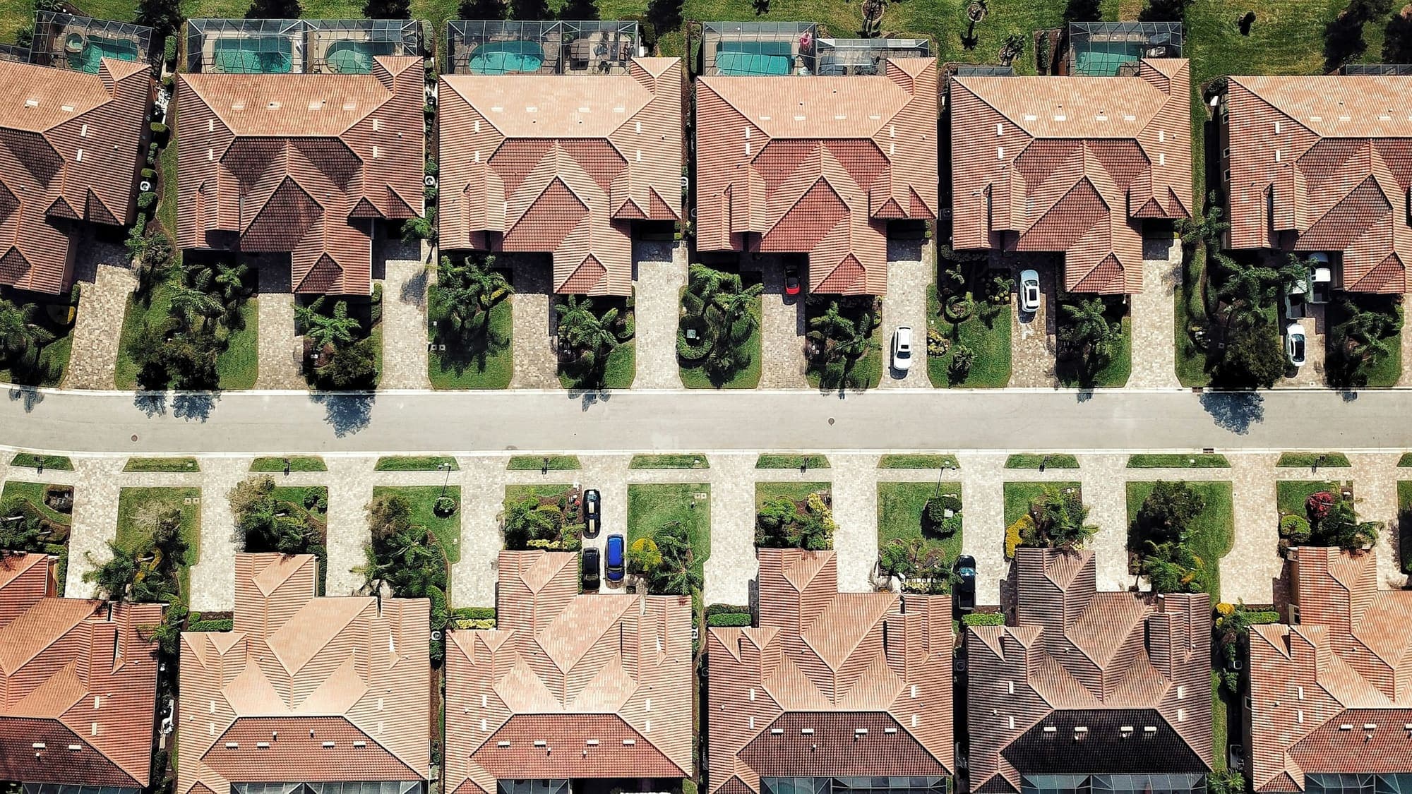 Aerial view of tile-roof homes with yards in a South Florida subdivision